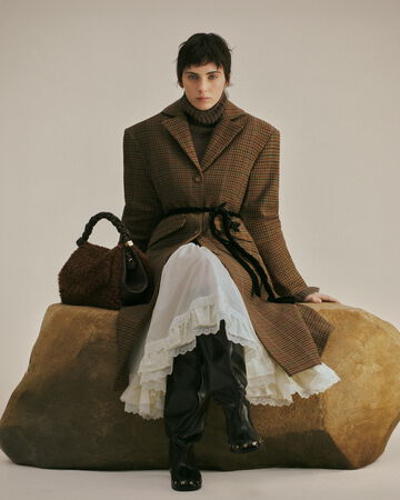 Model wearing brown coat and lace skirt from the Fall/Winter 2026 collection
